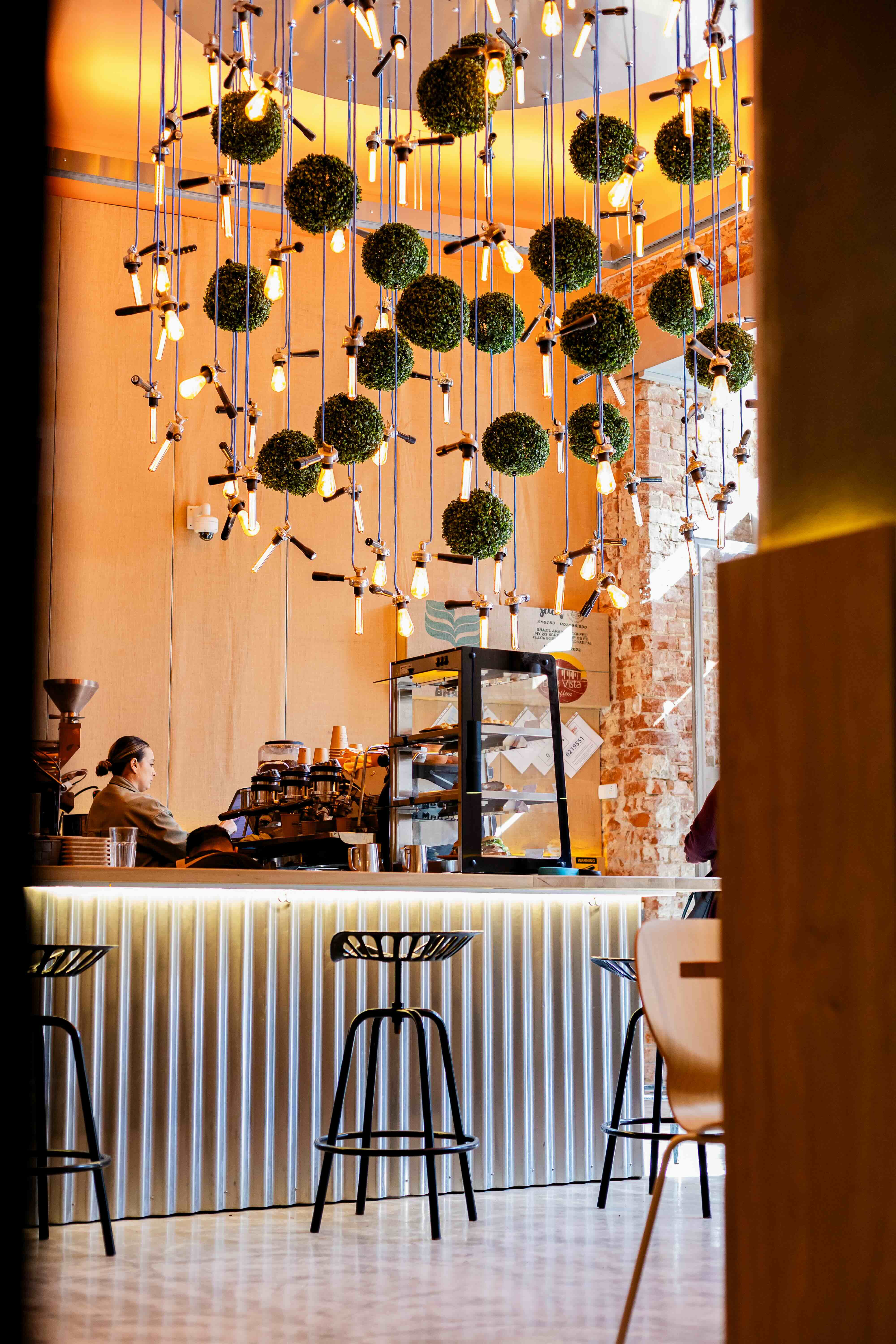 Bruma bar interior — suspended green spheres and Edison bulbs